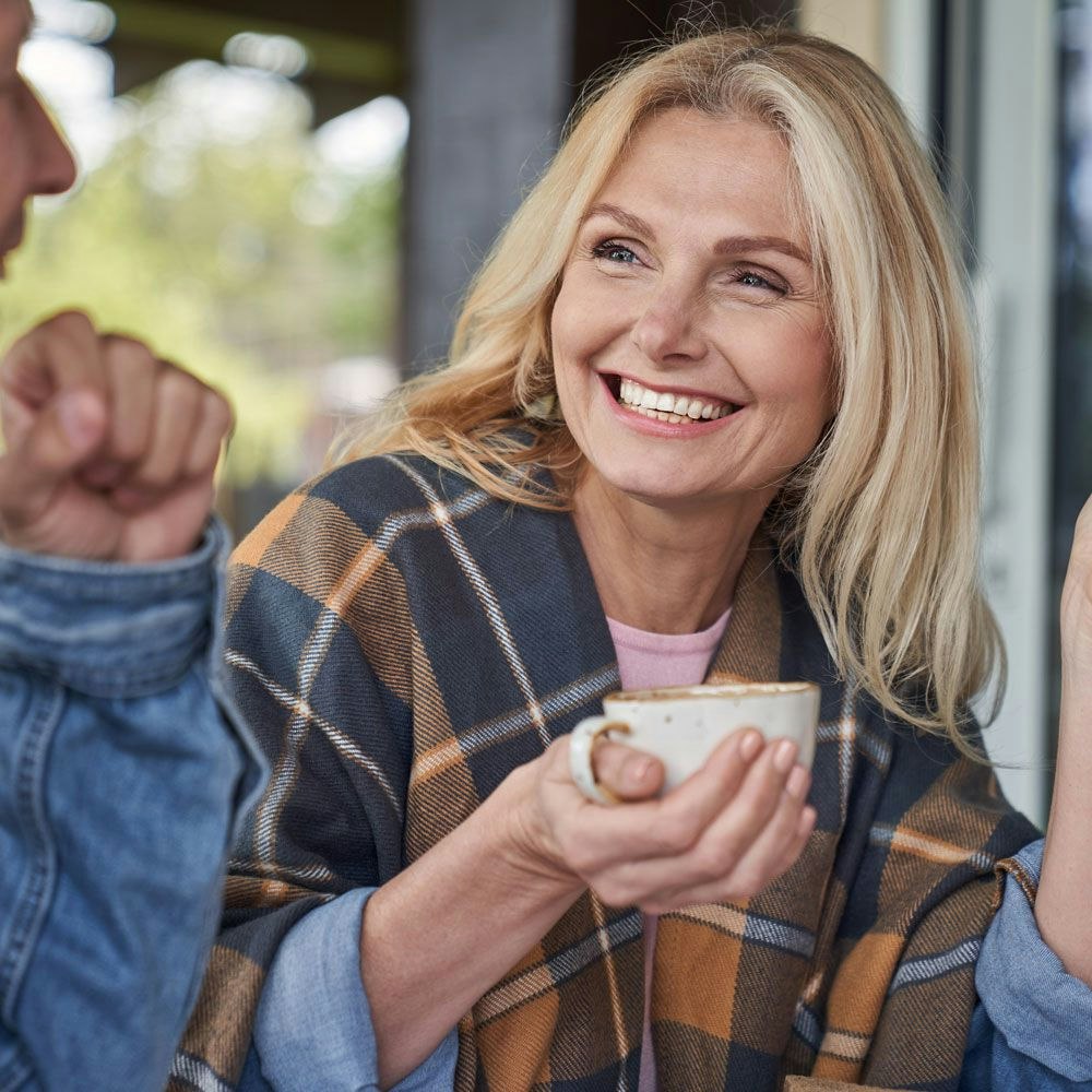 woman holding a coffee smiling with friends