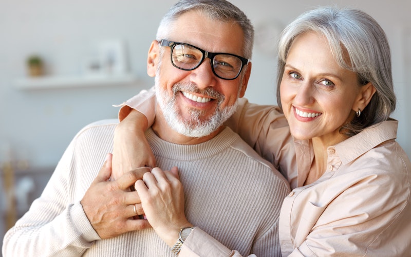 Older smiling couple after dentures treatment